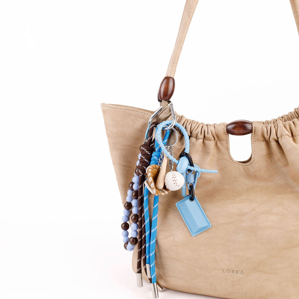 Handmade seed pod charm hanging from a canvas handbag