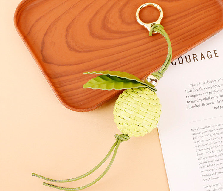 Handmade leaf accessory clipped to a handbag handle