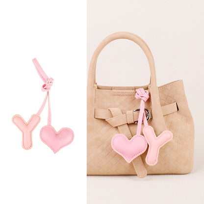 Small stuffed heart hanging near a zipper pull