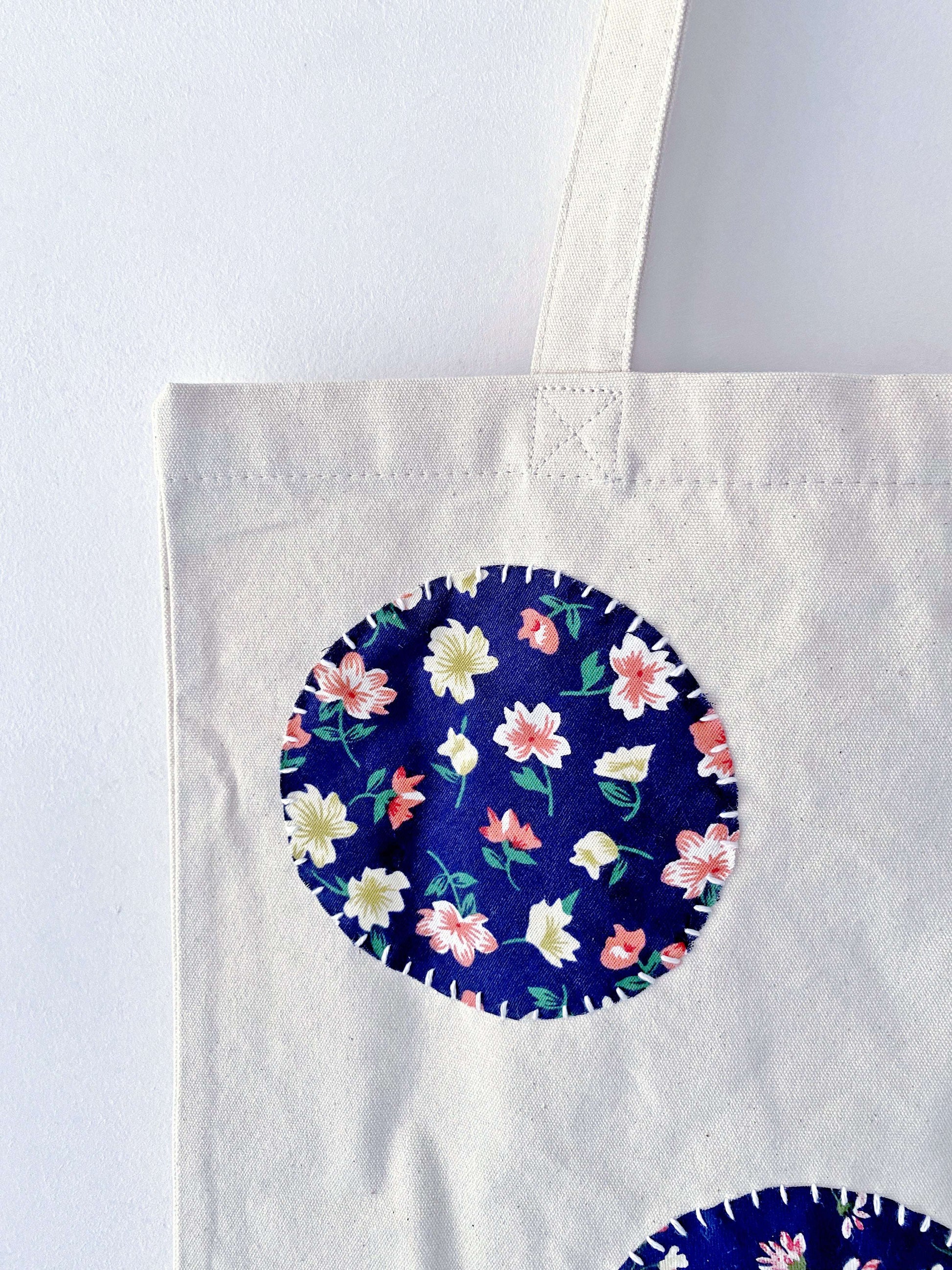 Large capacity beach tote made of breathable natural canvas showcasing intricate hand-sewn fabric art.