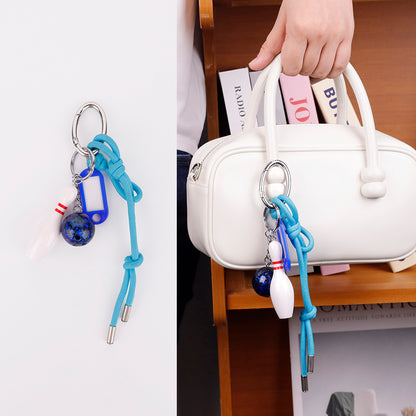 Rope keychain accessory styled on a neutral handbag