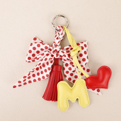 Small handmade bag accessory with a red bow and tassels