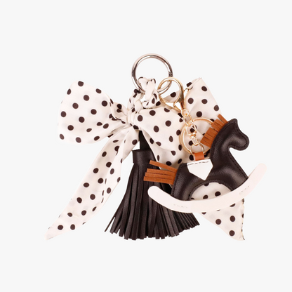 French polka dot silk ribbon tied around a dark leather handbag strap