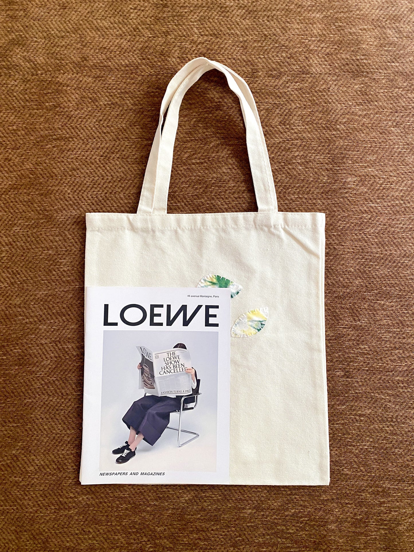 Minimal tote bag with stitched patchwork held casually during weekend errands