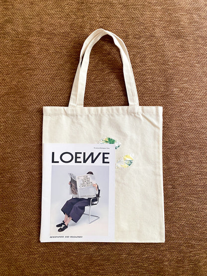 Minimal tote bag with stitched patchwork held casually during weekend errands