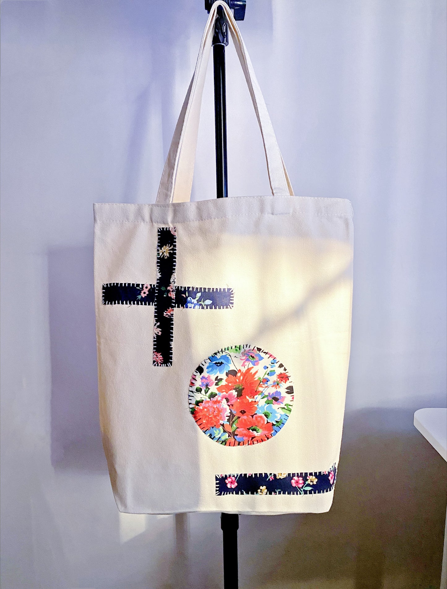 Roomy cotton canvas bag with hand-sewn geometric motifs, bridging the gap between functional grocery carrier and bespoke wearable art for daily use.