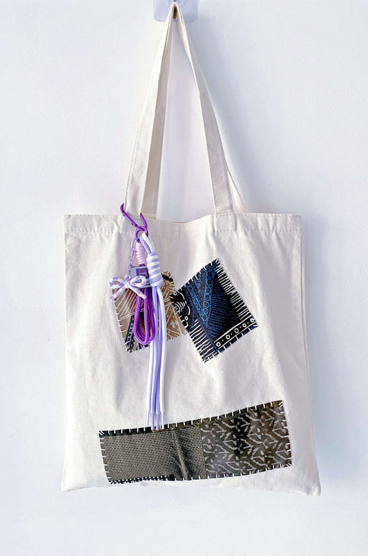 Large capacity canvas tote resting on a wooden bench in a sunlit room.