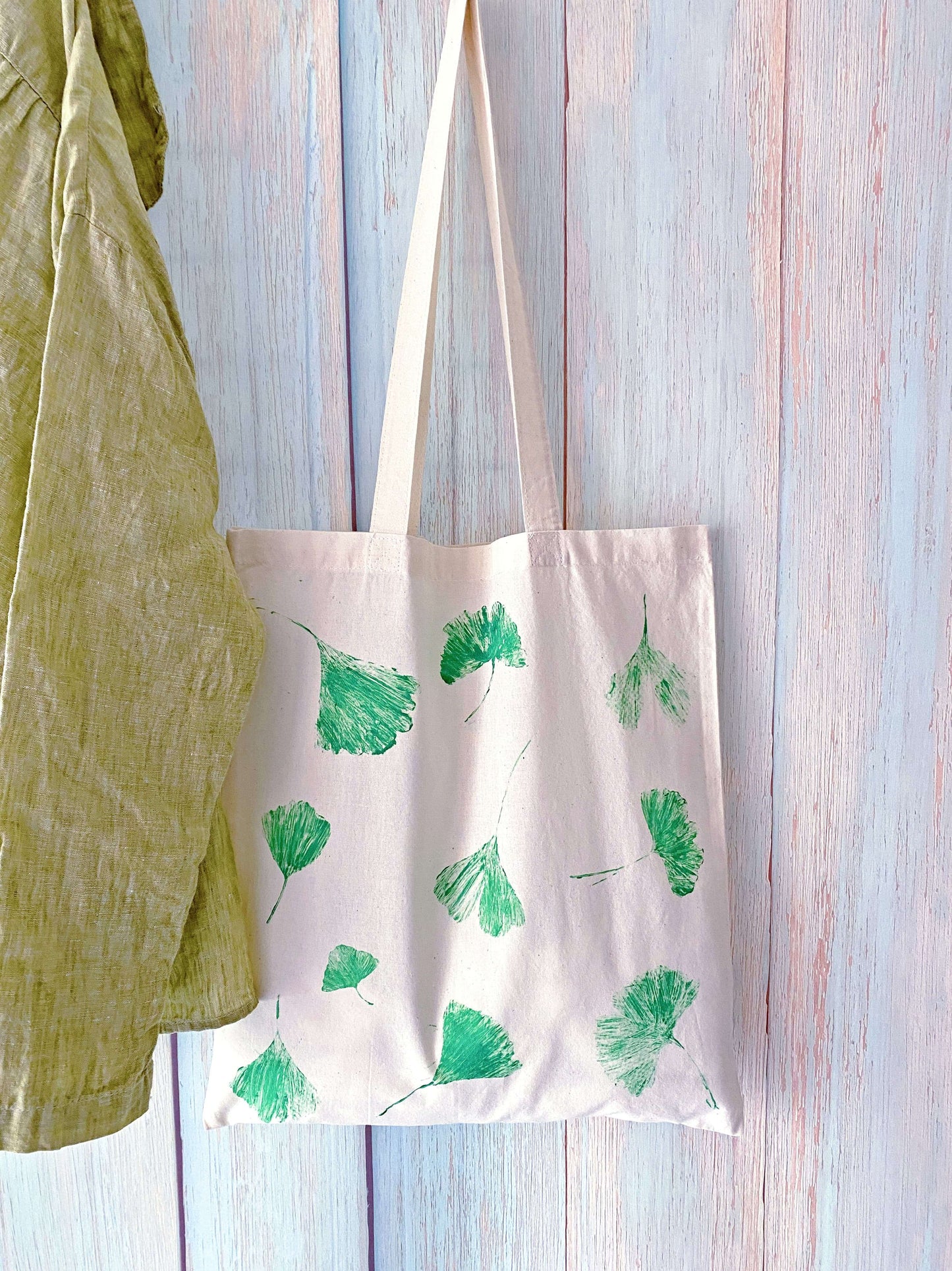 relaxed drape cotton tote with natural leaf dye pattern hanging on a simple wall hook