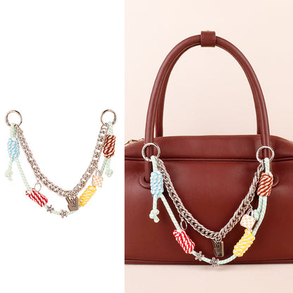 Layered dopamine cord key holder dangling from a modern bucket bag