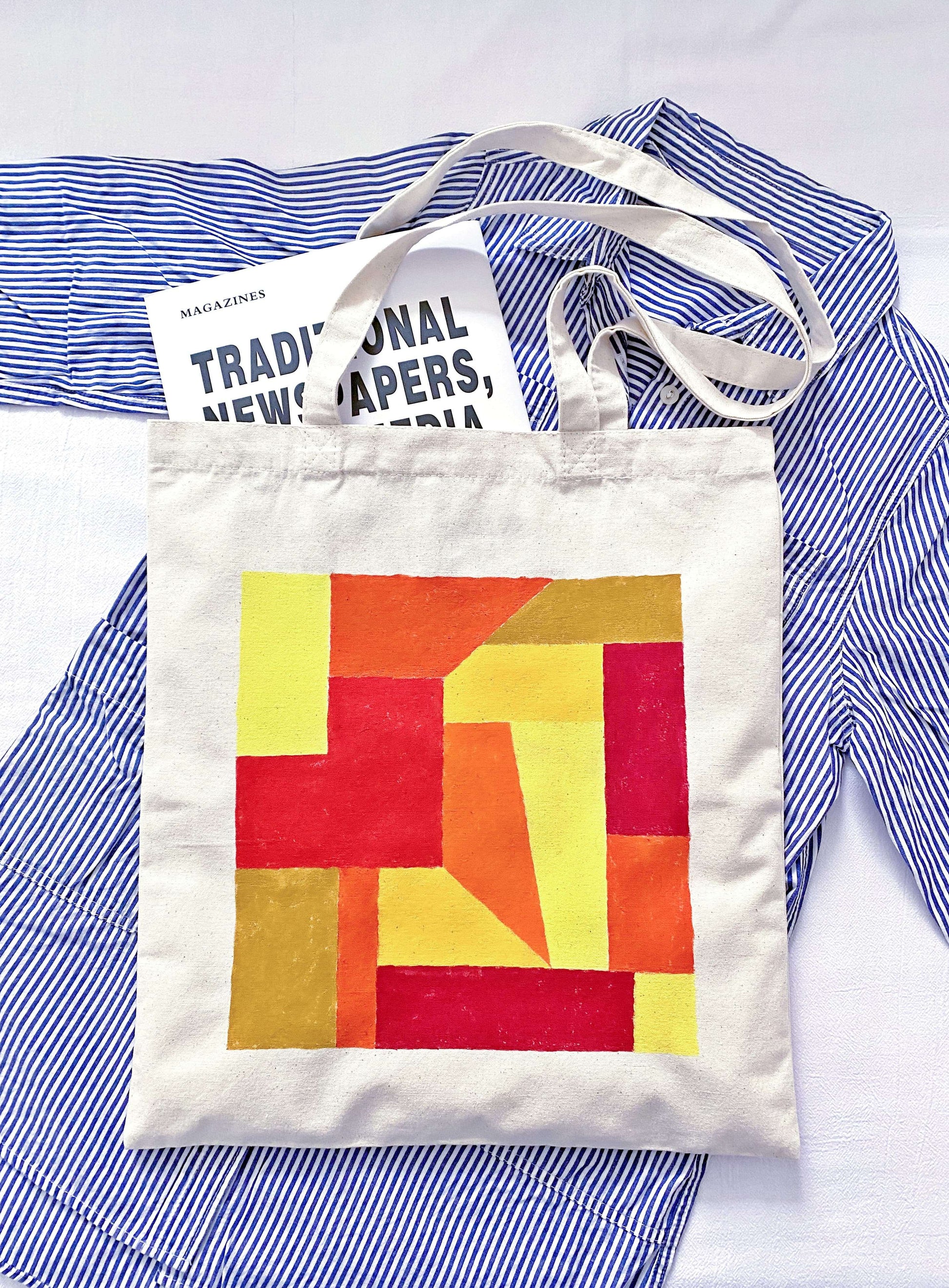 Person carrying a slouchy oversized tote bag during a morning flower market run.