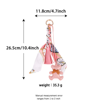 Bear purse charm accessory styled on a textured woven canvas summer tote