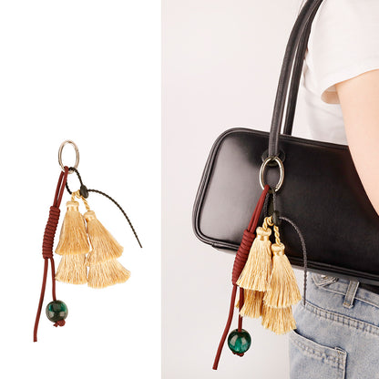 Woven utility charm adding pop of color to black nylon purse