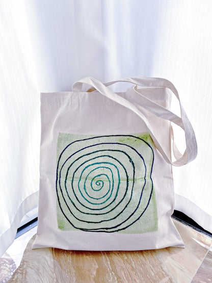 Spacious interior of a sturdy canvas bag holding a laptop, book, and sweater.