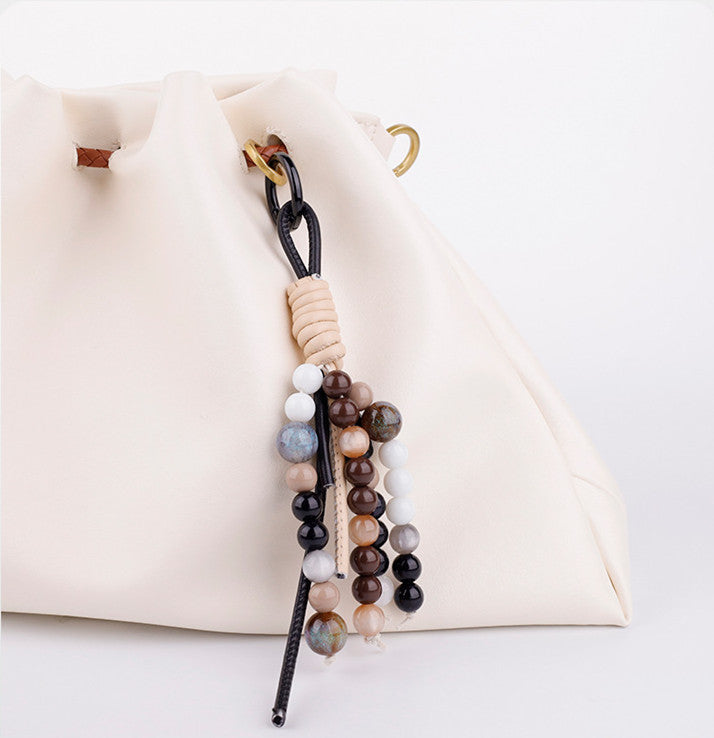 Unique artisanal beaded bag decoration styled as a thoughtful handmade birthday gift in a box