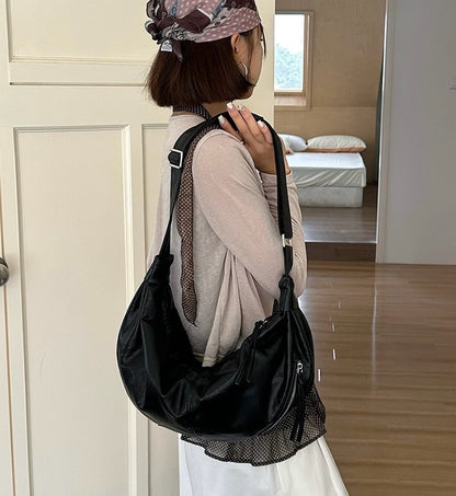 Women's sling handbag styled with a casual outfit.