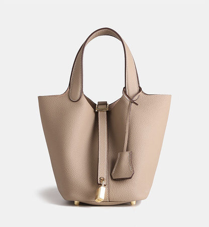 fashionable small leather bucket bag paired with neutral clothing
