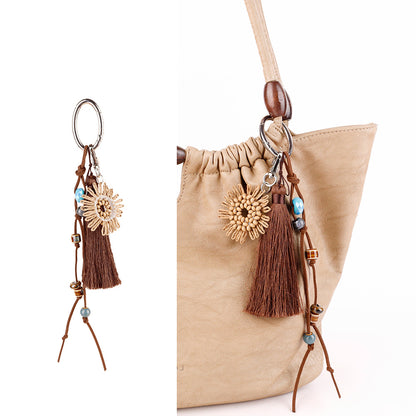 Textured woven ornament hanging beside a bag handle