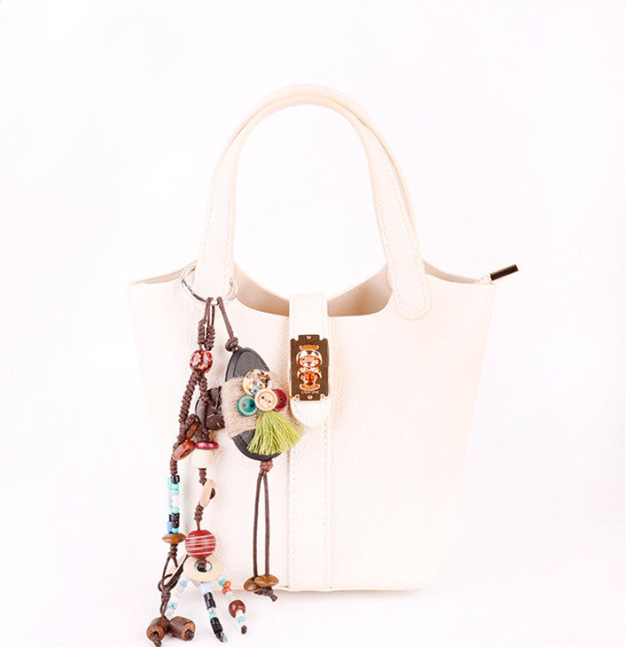 Natural wood bead charm styled on a leather handbag