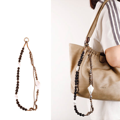 Decorative pendant paired with a simple leather-look handbag