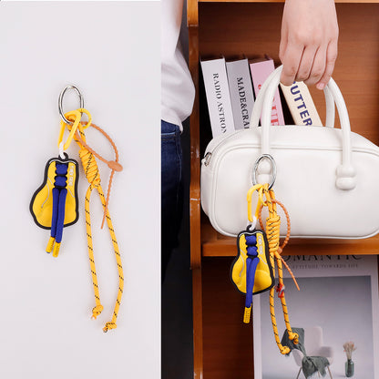 Sporty yellow keychain pendant photographed on an athletic gym bag strap