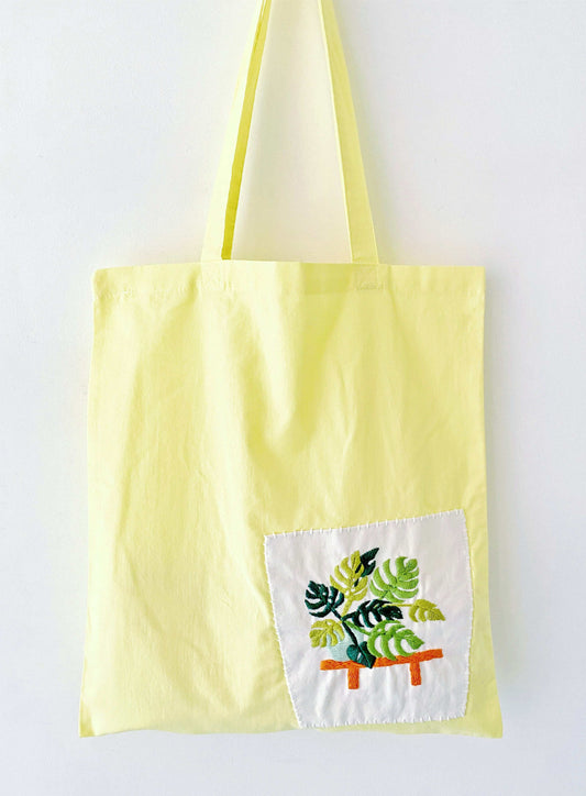 Bright yellow cotton tote with delicate hand-stitched flower pattern