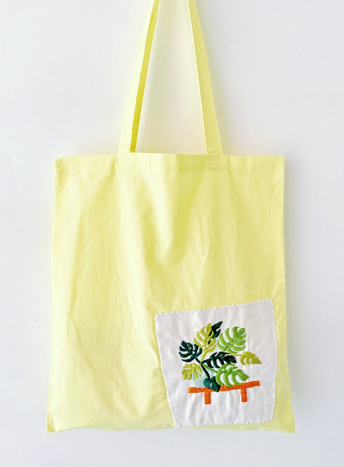 Bright yellow cotton tote with delicate hand-stitched flower pattern
