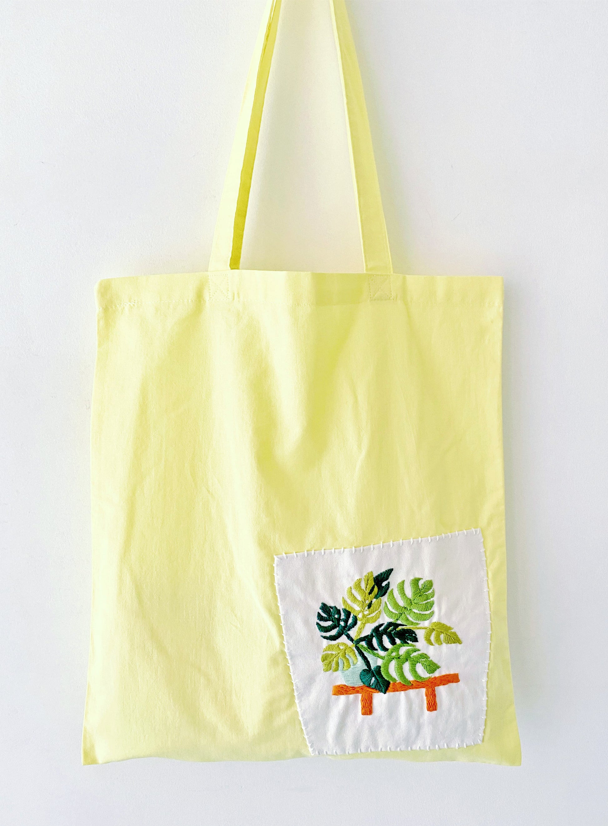 Bright yellow cotton tote with delicate hand-stitched flower pattern