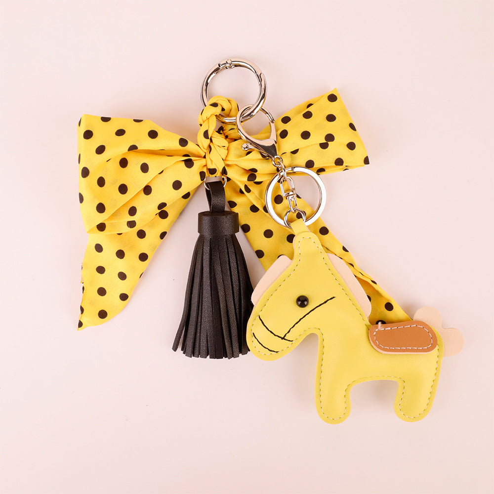 Polka dot scarf accessory with a flowing yellow tassel